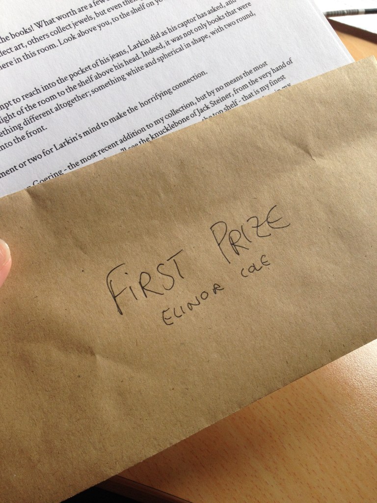 A brown envelope that reads 'First Prize Elinor Cole', held above a printed page of a short story.