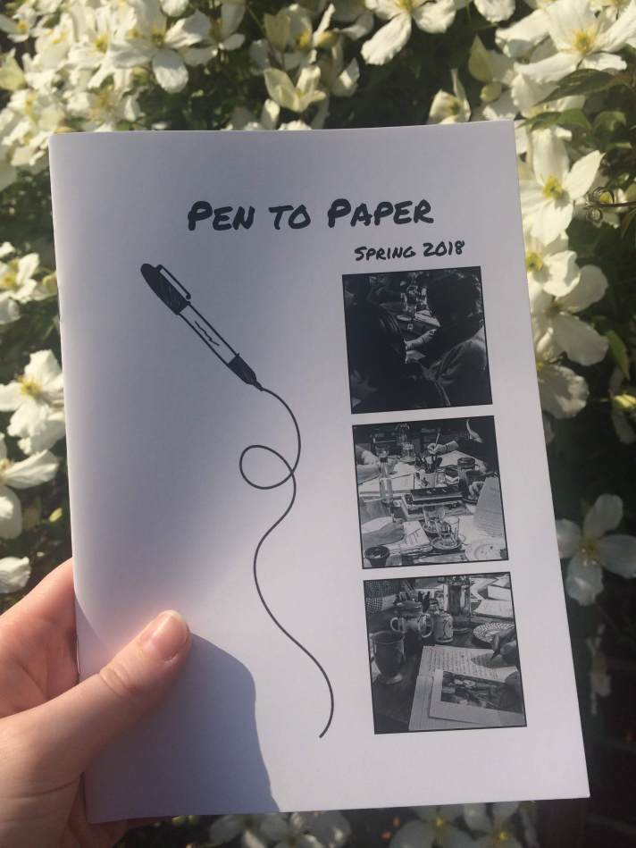 A booklet is held up against a floral backdrop. The cover reads 'Pen to Paper, Spring 2018', and features a cartoon pen and three small snapshots of writers writing.
